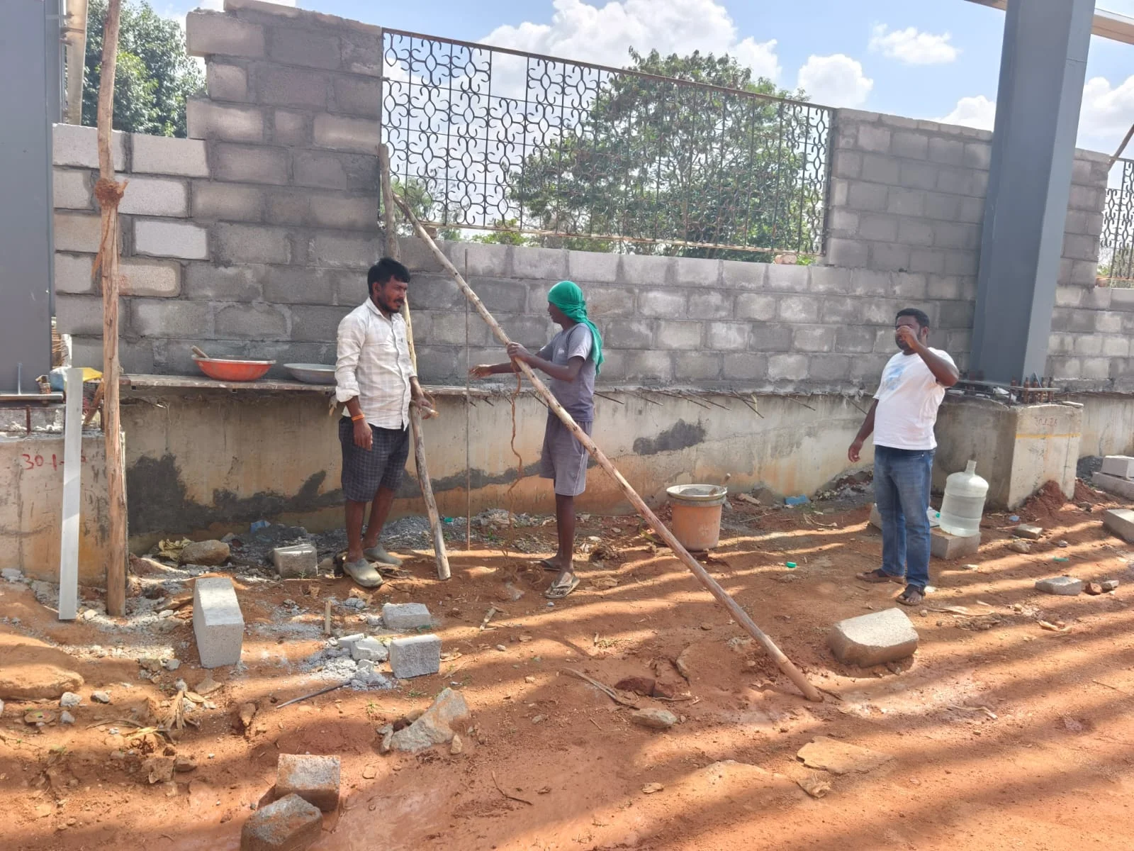 Construction team beside the block wall and window grille