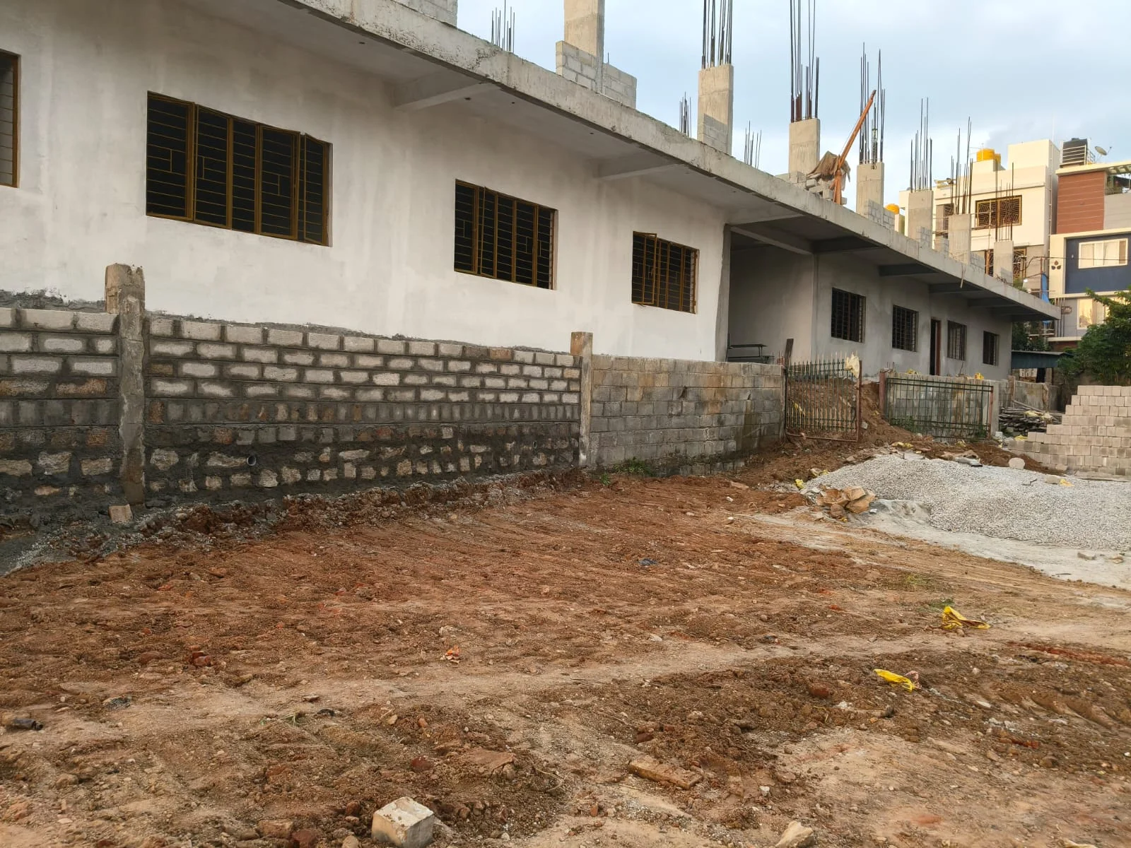 Building construction with a boundary wall and exposed column reinforcement