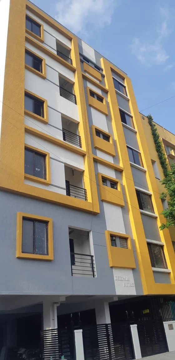 White and yellow building facade with balconies and entrance gates