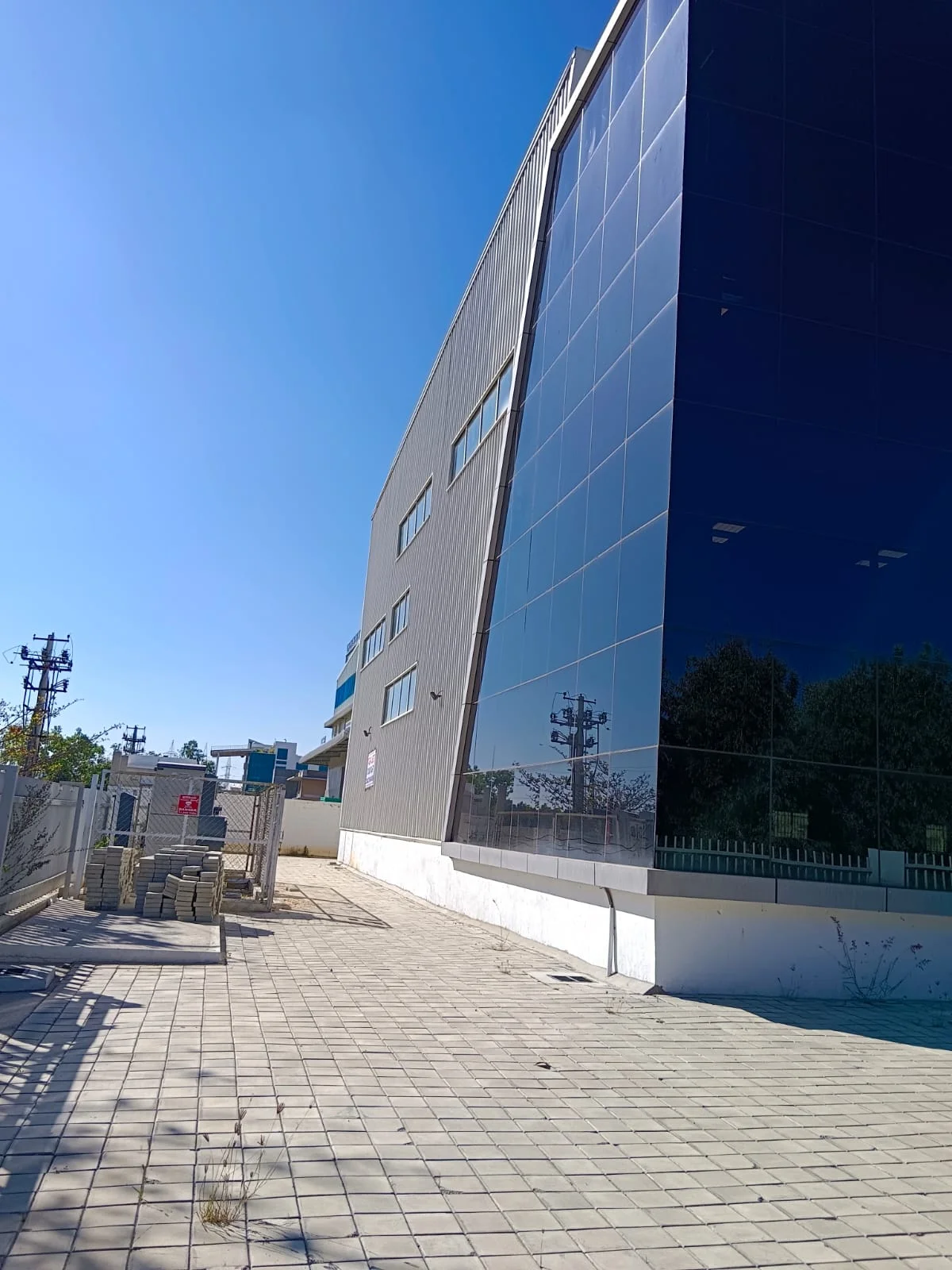 Industrial building exterior with glass curtain wall and paved approach