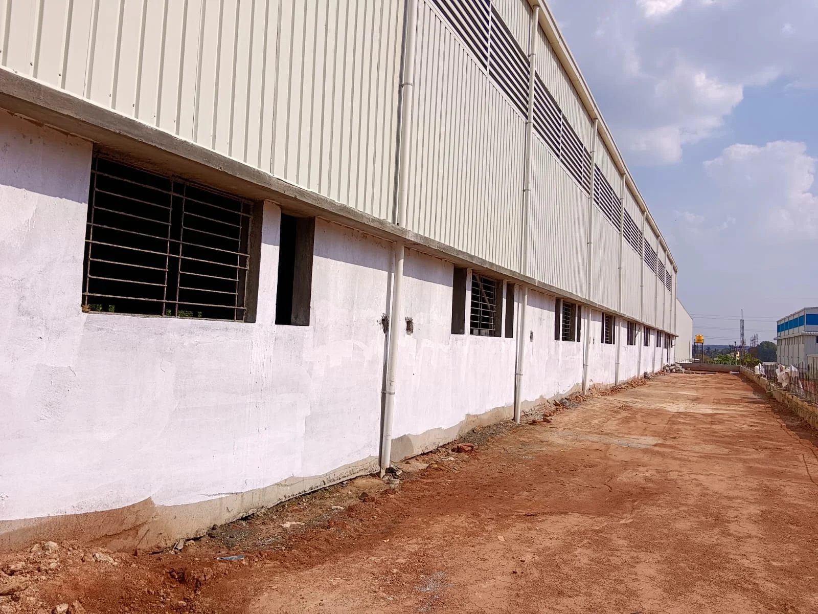 Factory exterior with metal sheet cladding and grilled windows