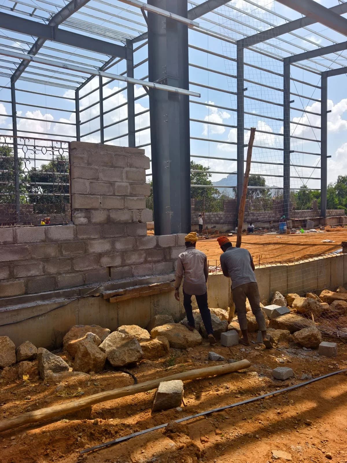 Masonry team working beneath the steel roof frame